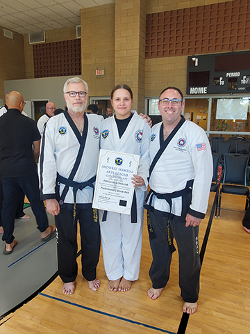 Aleksandra receiving black belt certificate